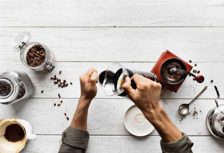person pouring coffee in a mug